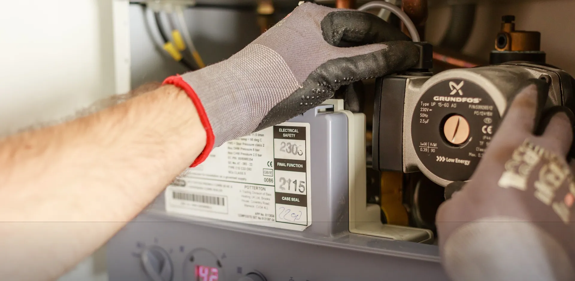 Artisan plombier en intervention sur une chaudière